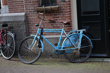 Fototapeta na wymiar Blue City Bicycle Against Brick Wall