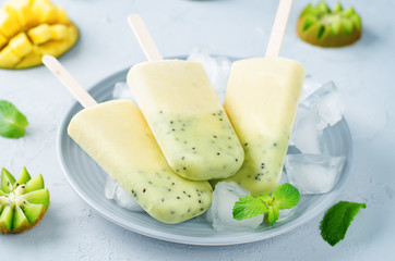 Mango Kiwi ice cream with fruits, mint and ices