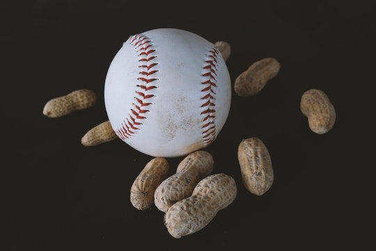 White Baseball With Ballpark Peanuts Against Black Background.  Ball Equipment For Sports Graphic.