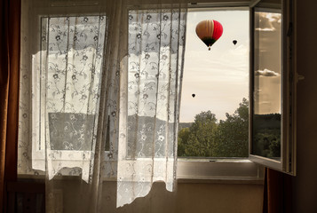 Fresh wind in the window. View from the window to the balloons