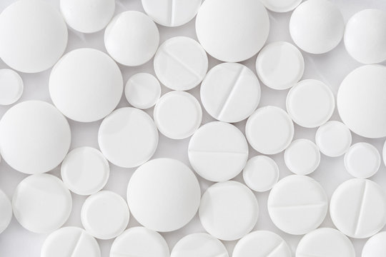Pile of many white drug pills laying in a pile © bravissimos