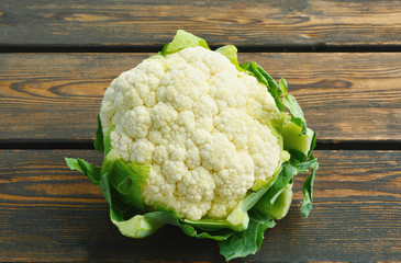 raw white cauliflower on wooden background