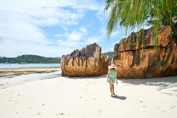 female tourist is walking on Laraie Bay's beach with granite rock, curieuse island, seychelles - 197798367