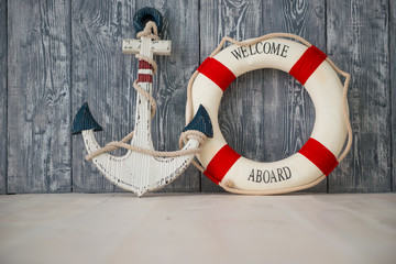 Composition on the marine theme with anchor and lifeline on wooden background