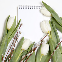 the White note pad in a frame of white tulips with a willow
