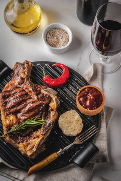Fresh grilled meat beef steak with with red wine, herbs and spices. Top view copy space white marble background