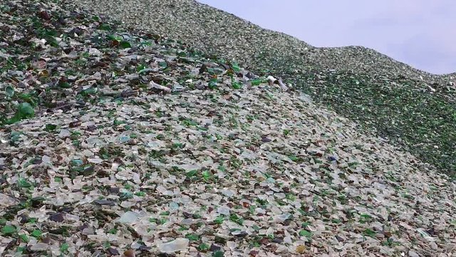 Mountain Of Glass Broken Multicolored Bottles. Glass Broken Bottles In Recycling Industry Factory. Crushed Of Recycled Glass Bottles At Factory. Recycling Of Waste From Glass Bottles. Panning.