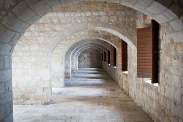 Fototapeta na wymiar Series of Leading Stone Archways Leading with Spaced Windows in a Cloisters