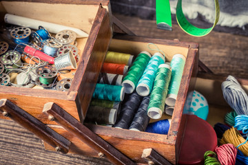 Fototapeta na wymiar Closeup of tailor's wooden box with colorful threads