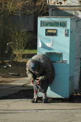 Old woman counting the money near soda water machine. Kyrgyzstan Bishkek 23.03.2006.