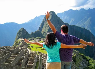 Crédence de cuisine en verre imprimé Machu Picchu a couple raising their arms in machu picchu expressing a feeling of freedom