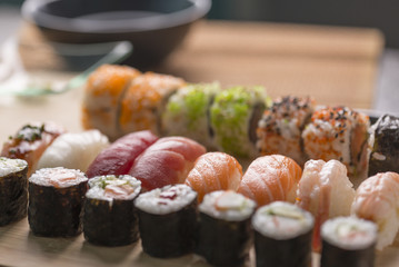Sushi Set sashimi and sushi rolls served on stone slate