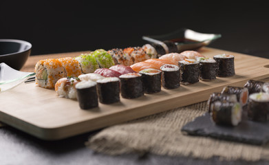Sushi Set sashimi and sushi rolls served on stone slate