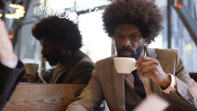 Two diverse business men discussing in a coffee shop one morning