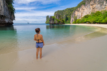 Young women wearing bikini relaxing standing in topical beach on Koh Hong islands in Andaman sea at Krabi near Phuket southern of Thailand