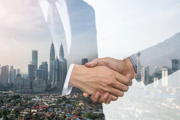 Gordijnen Double Exposure of a businessman handshake on Kuala lumpur cityscape skyscraper Malaysia background. © Travel man