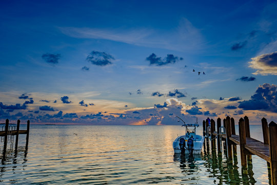 Fototapeta Sunbeams strike the ocean water off in the distance as the sun sets in the Florida Keys