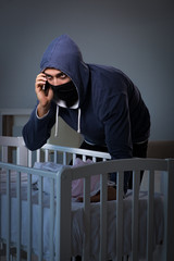 Criminal stealing baby in human child traficking concept