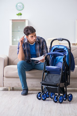 Young father assembling baby pram at home