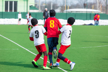 young boys play football, show dribbling, make passes to win on the winter field