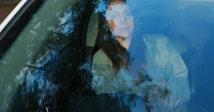 Young woman looking through a car window