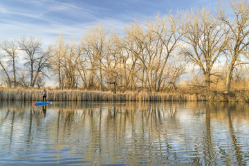Paddling stand up paddleboard on a calm lake