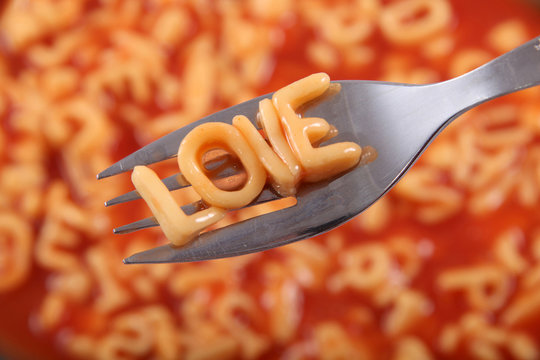 Spaghetti letter spelling the word Love with the letters held up on a fork.