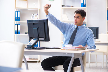 Handsome businessman employee sitting at his desk in office