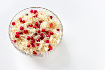 Sauerkraut with cranberries in glass bowl on white background with blank copy space.