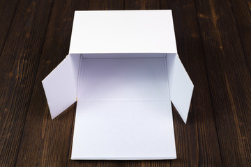 Empty white gift box or tray for mock up on dark wooden table with copy space.