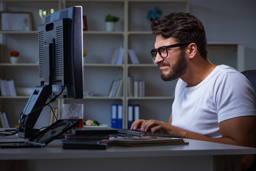 Young man staying late in office to do overtime work