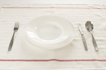 dish spoon fork knife on white tablecloth, cutlery stainless silver