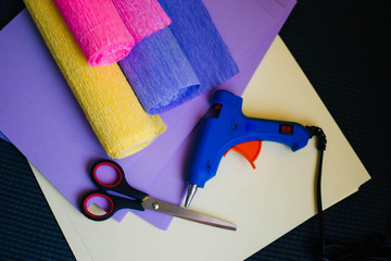 tools for handmade. Rolls of corrugated paper, glue gun and scissors. Counterfeits from colored...