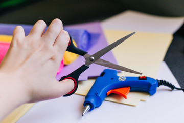 tools for handmade. Rolls of corrugated paper, glue gun and scissors. Counterfeits of colored...