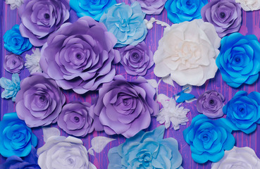 blue, purple and white paper flowers on a lilac wall. Photo Area
