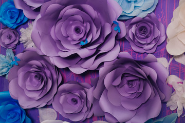blue, purple and white paper flowers on a lilac wall. Photo Area