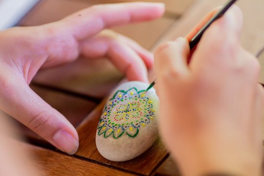 Girl colouring pebbles