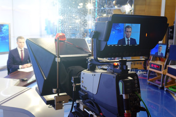 The news presenter reads the text on the teleprompter.Camera in the office. TV studio.