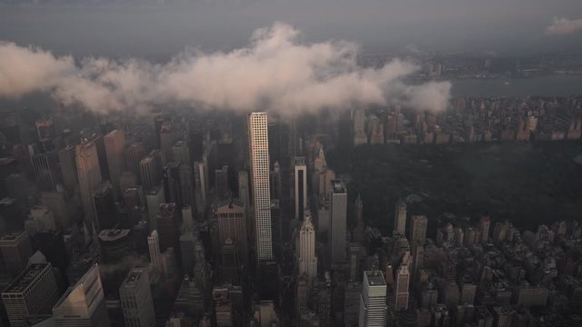 New York City aerial view of Midtown, the Upper East Side and Central Park under low level clouds from 59th Street at sunrise.