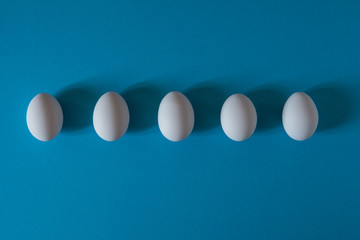 White eggs on a blue background top view