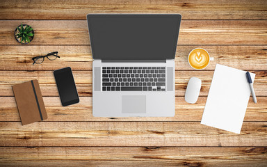 Modern workspace with coffee cup, paper, notebook, tablet or smartphone and laptop copy space on wood background. Top view. Flat lay style.