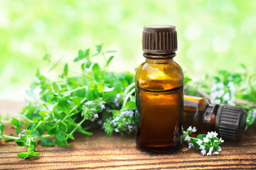 Thyme (thymus) essential oil on flowers and plants background