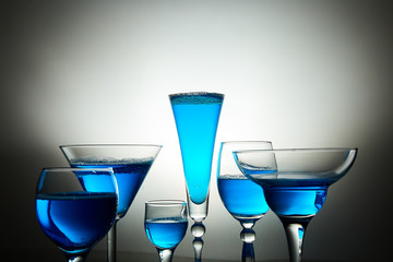 Many glasses with blue champagne or cocktail.