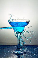 Glass with blue champagne or cocktail. Levitation