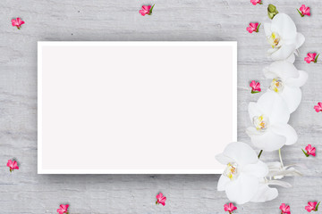 Abstract floral pattern, small flowers on the cardboard with a sheet of paper for text, top view, flat lay, mock up