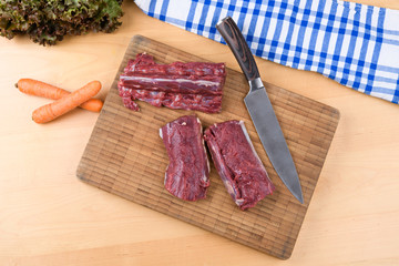 saddle of venison on wooden board