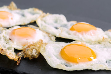 fried eggs of quail on black stone