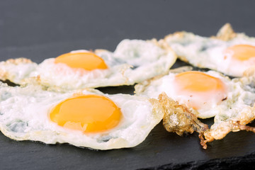 fried eggs of quail on black stone