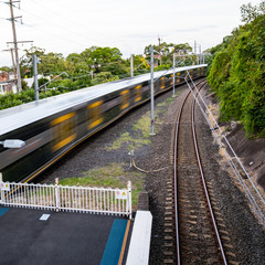The platform of train station with train in motion, Sydney, Australia. Blurred motion of a train, shooting from a high angle.