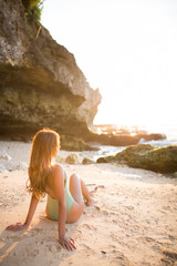 Young girl relaxing on a tropical beach at sunset 